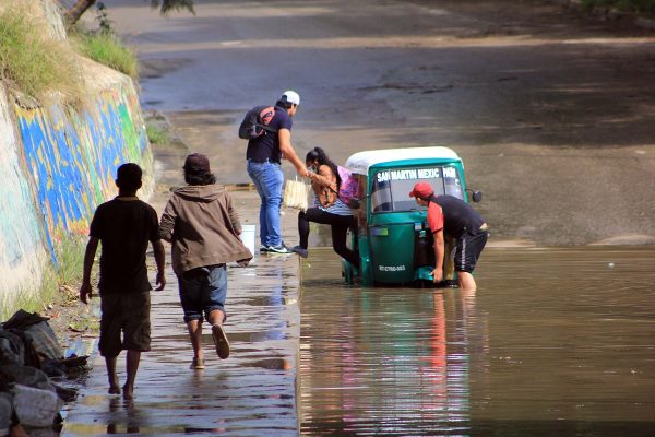 Mototaxi intenta cruzar un puente inundado