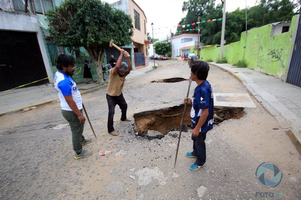 Vecinos deciden quitar el asfalto que quedó sobrepuesto tras el hundimiento de la tierra.